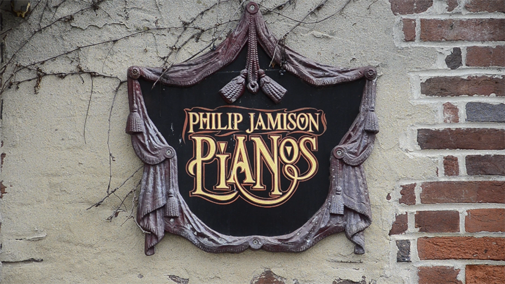 A sign on a building that reads Philip Jamison Pianos.