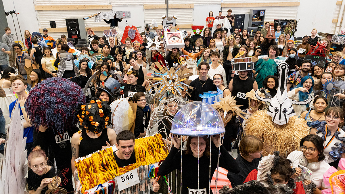 A group of students wearing sculpture they created pose for a photo in the MAGIC soundstage.