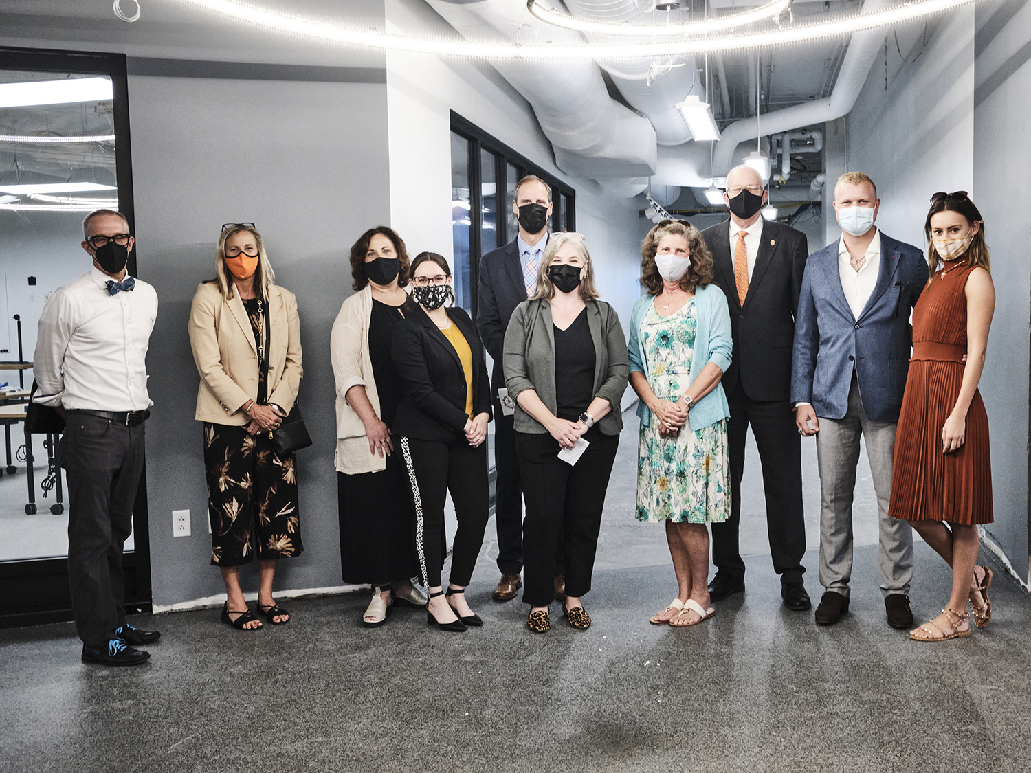 A group of people pose for a photo within the photo facility renovation.