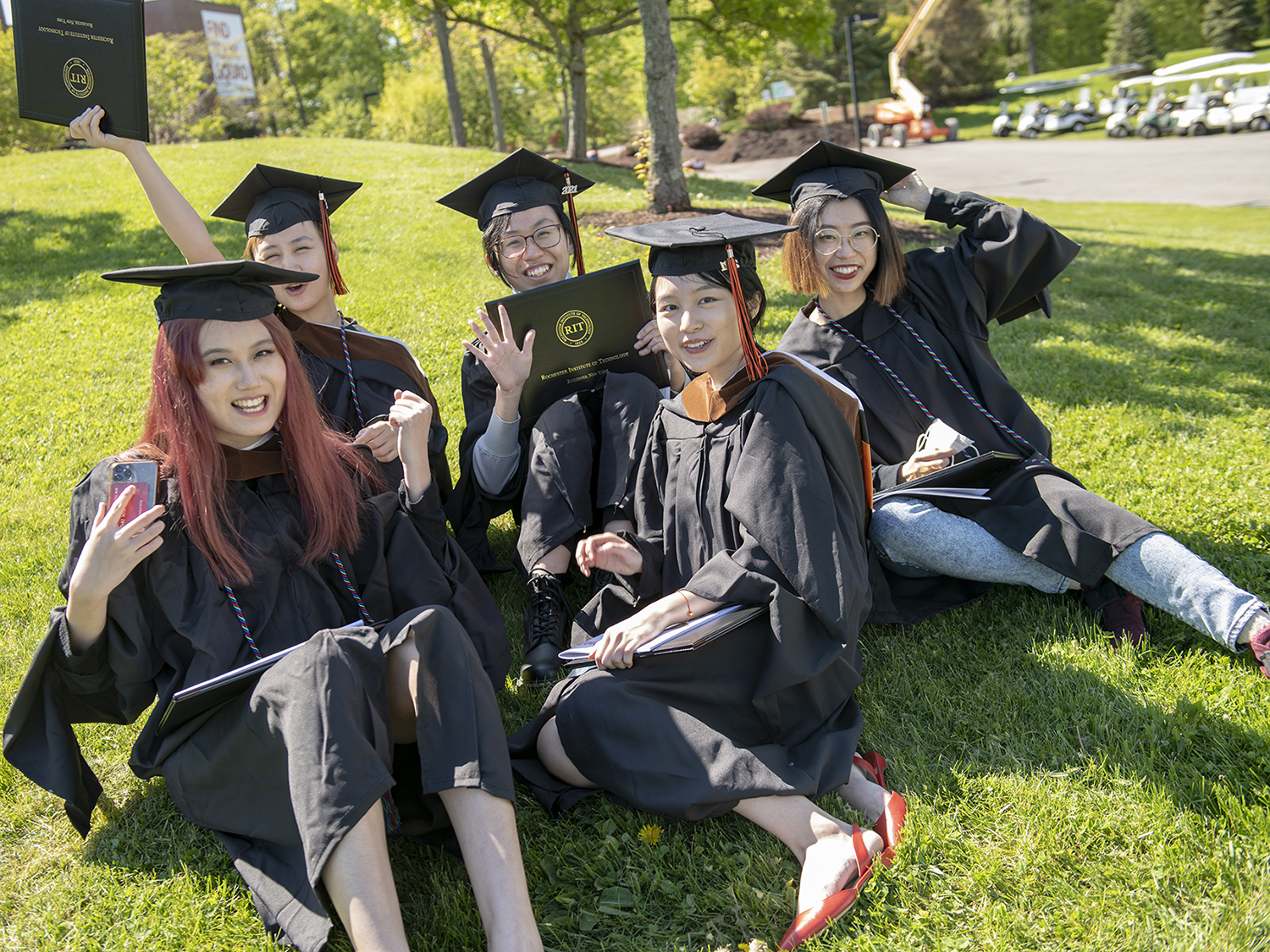 A group of students in regalia celebrate at commencement.