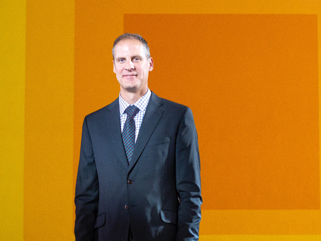 Dean Todd Jokl stands in front of the Albers mural on the RIT campus.