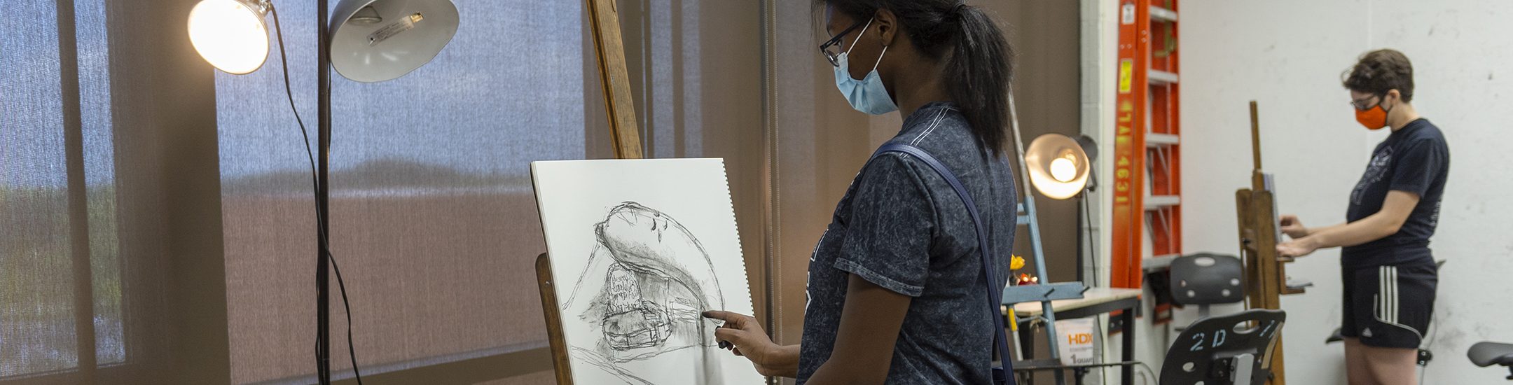 A student works on a still-life drawing in the studio.