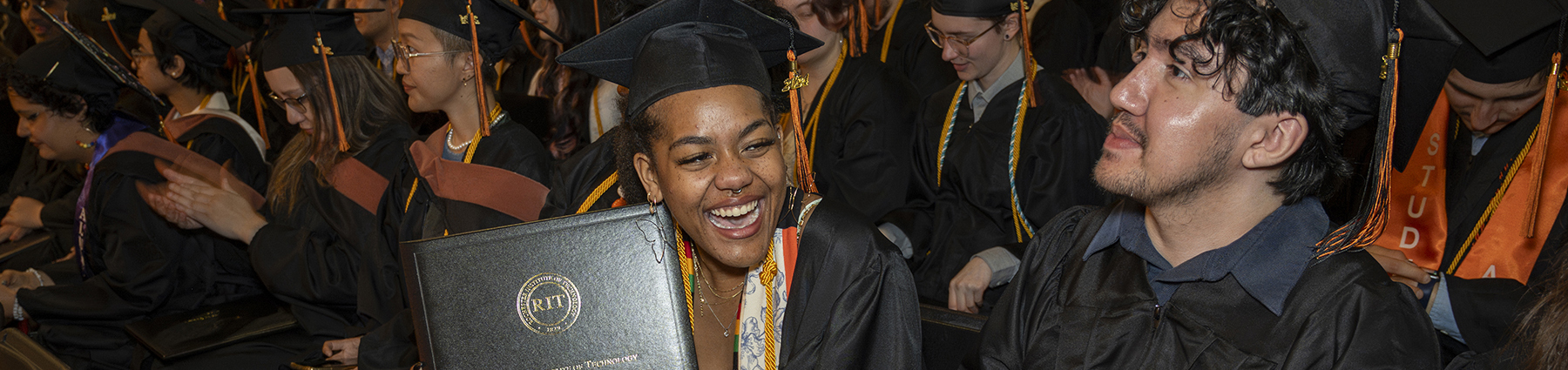 Students smile during commencement.