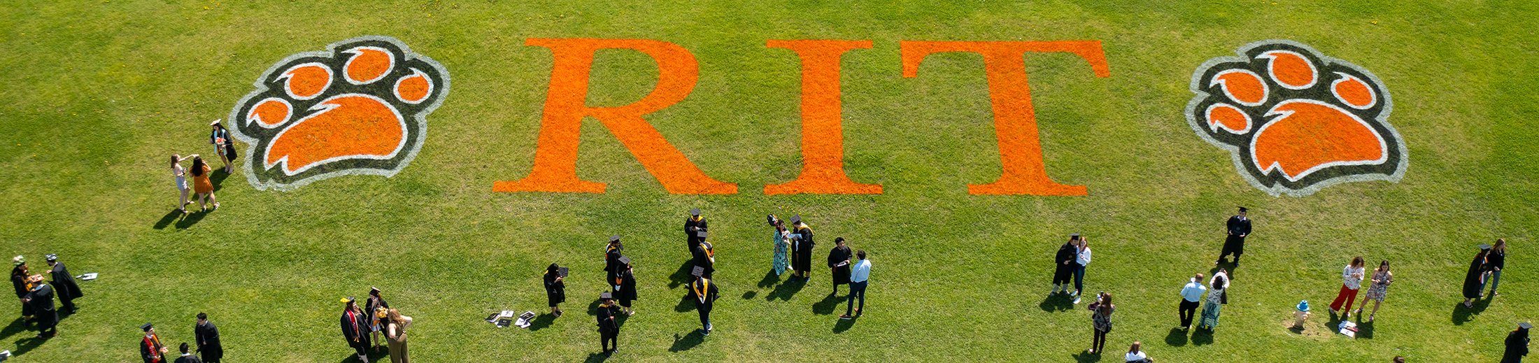 An overhead view of the RIT logo on a patch of grass during commencement ceremonies.
