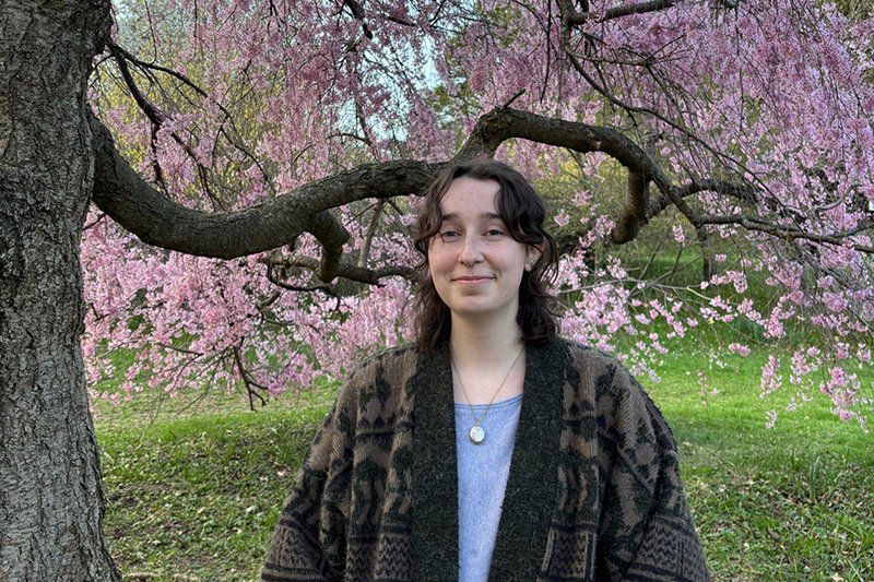 Audrey Thompson with a cherry blossom tree in the background.
