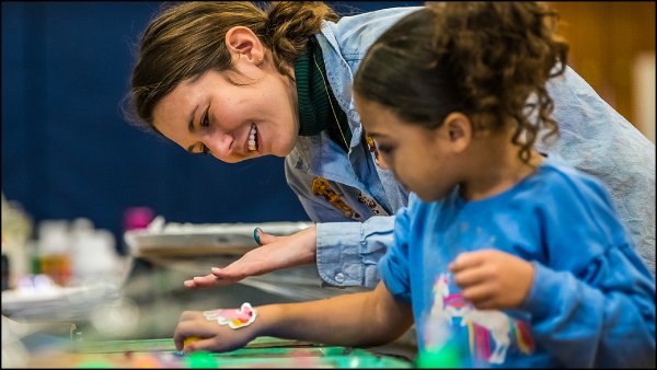 Adult working with a child on a project