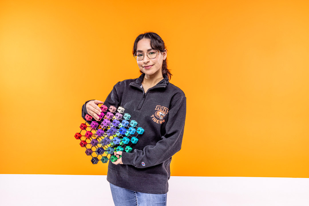 Andrea Avendano Martinez portrait against an orange background.