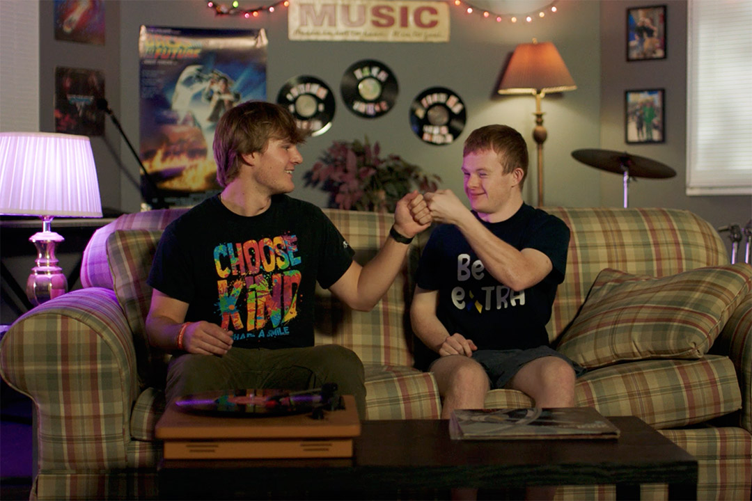 Nash Snyder and his brother Jake sit on a couch and do a fist bump.