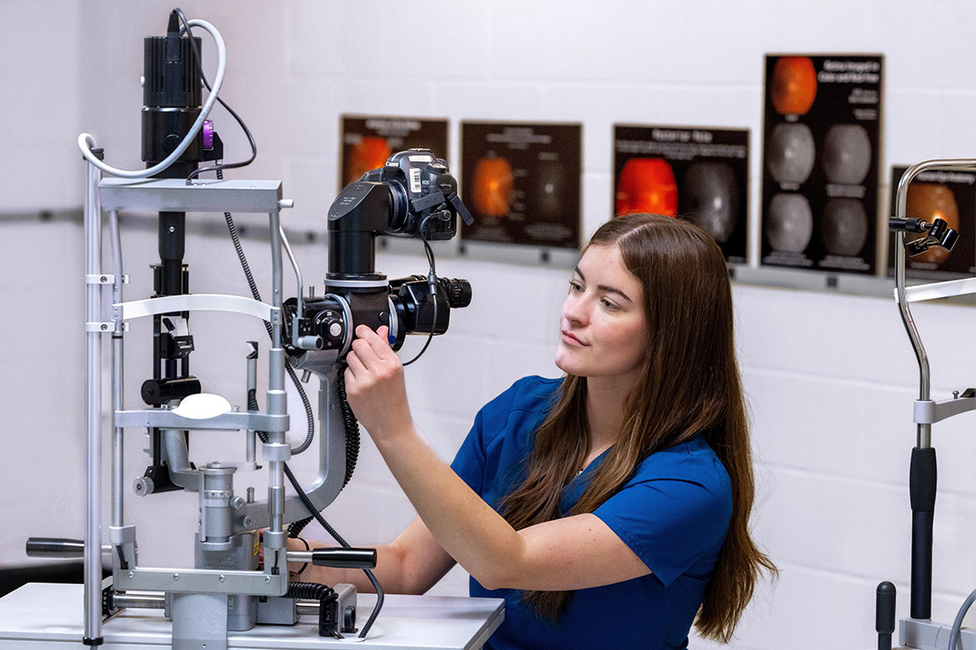 Paige Wright operates ophthalmic equipment.