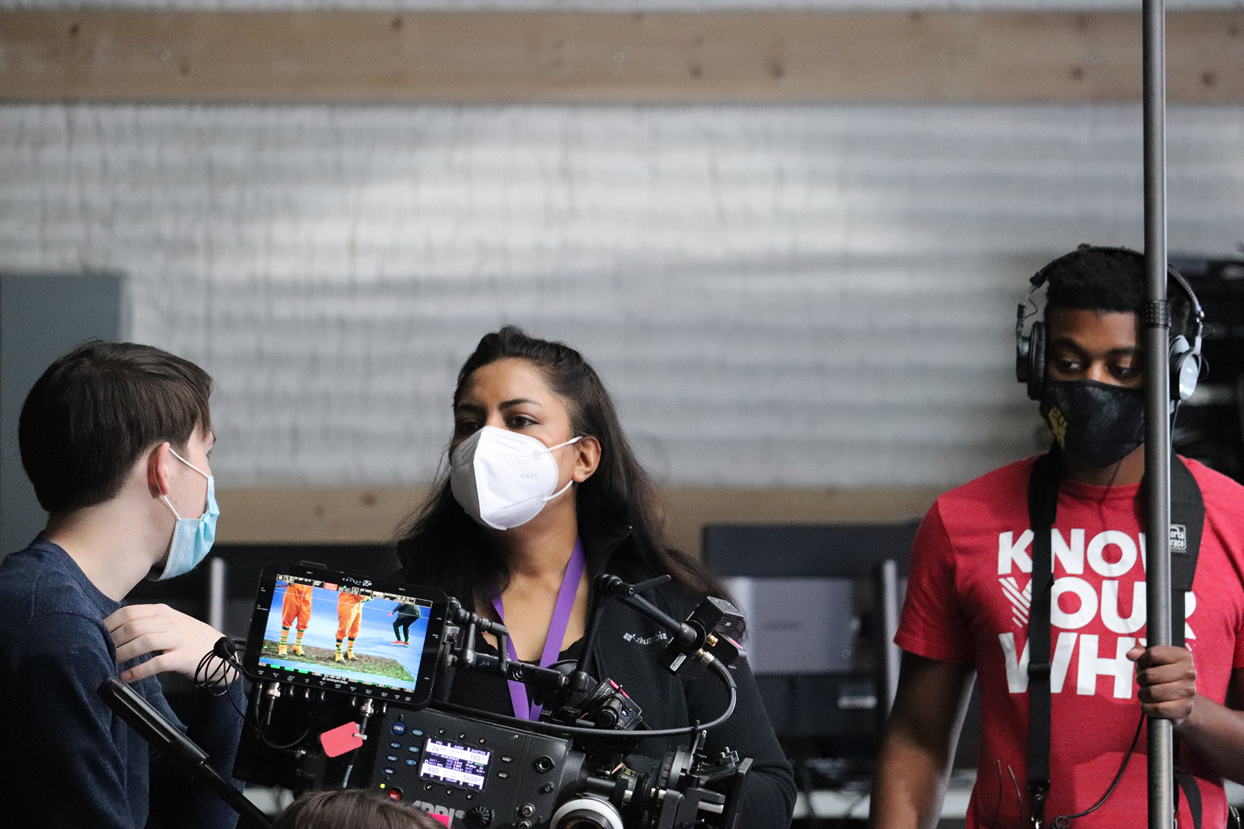 Ambarien talks with a student on the set of a production.