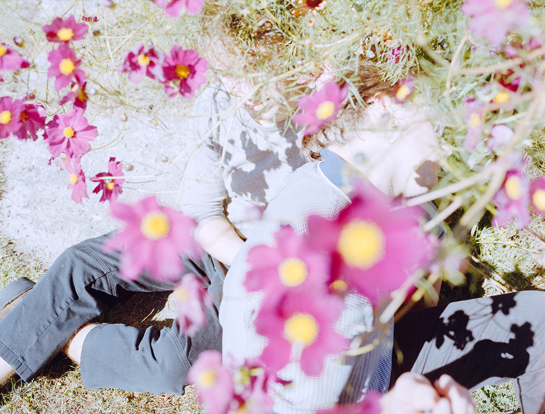 A person sits beneath a flowering tree.