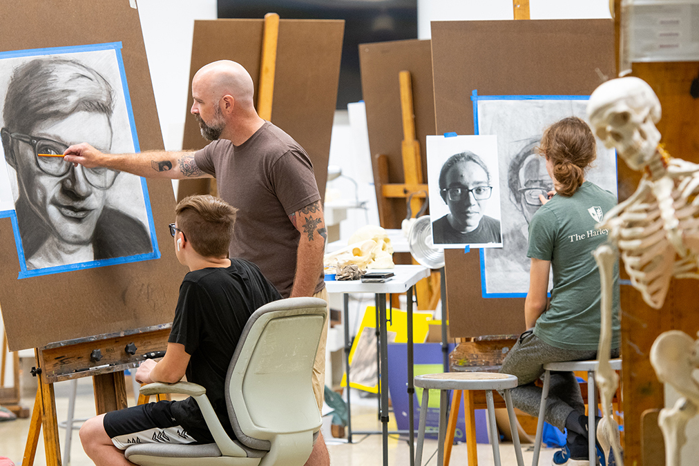 Faculty Denton Crawford instructs a drawing student.