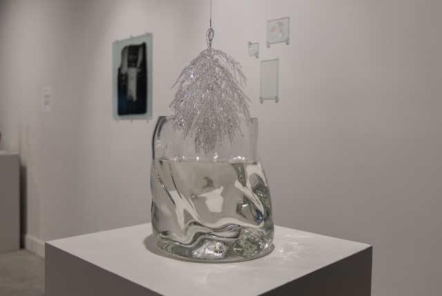 A glass sculpture sits on a platform.
