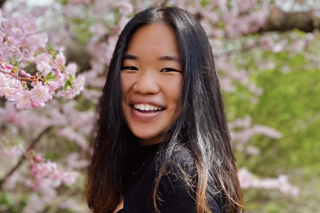 Stephanie Liu poses for a photo in front of trees.