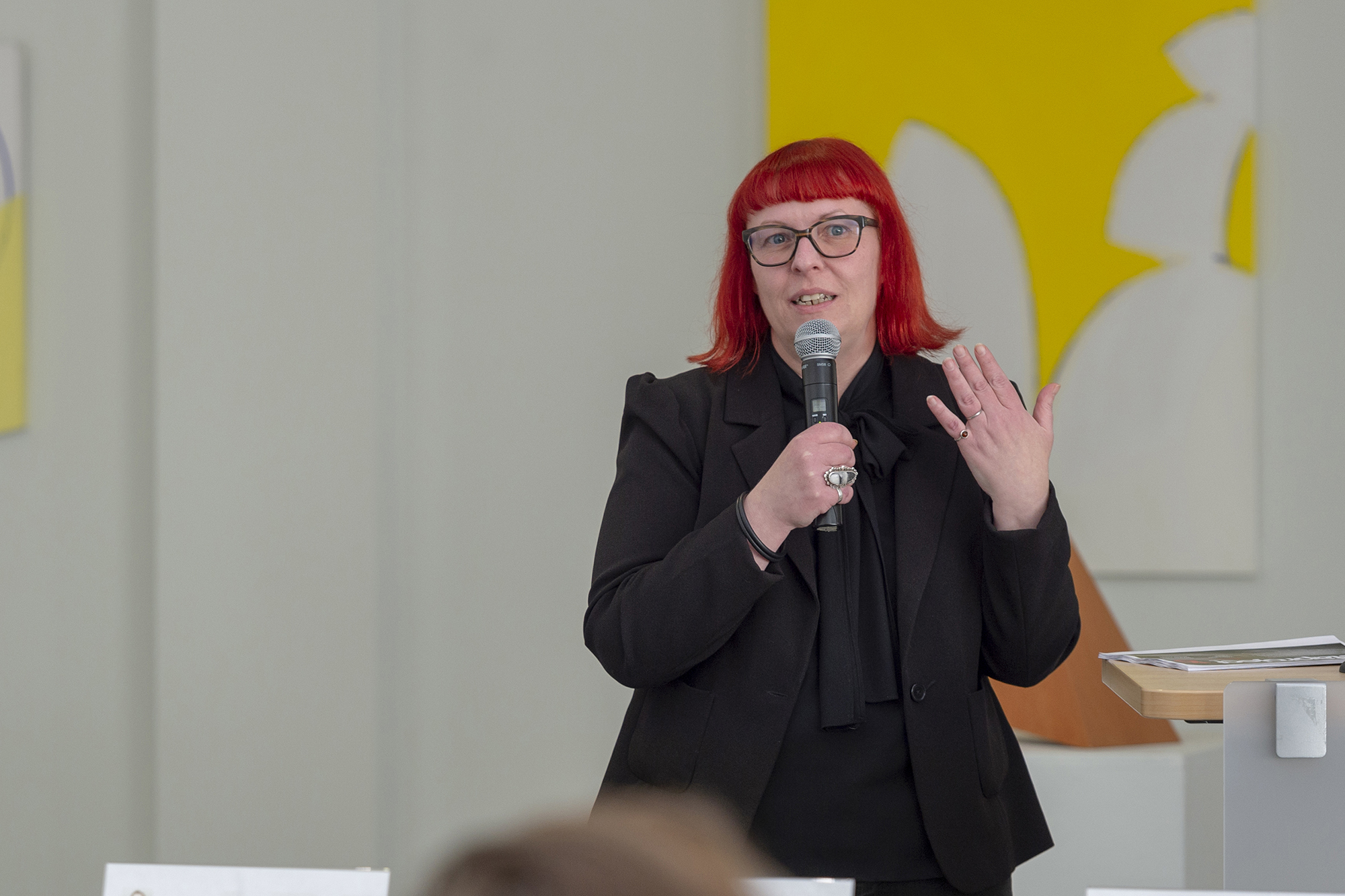 Jennifer Whitlock talks into a microphone.