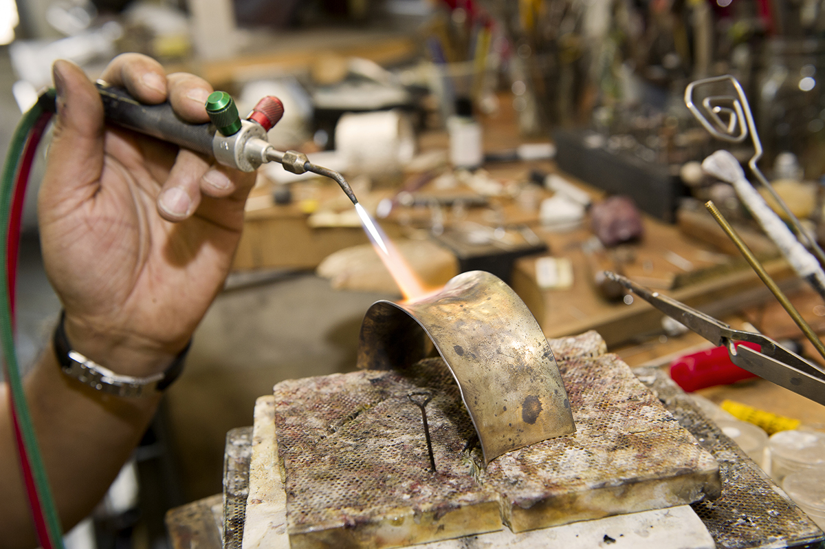 A piece of metals gets heated up in a studio space.