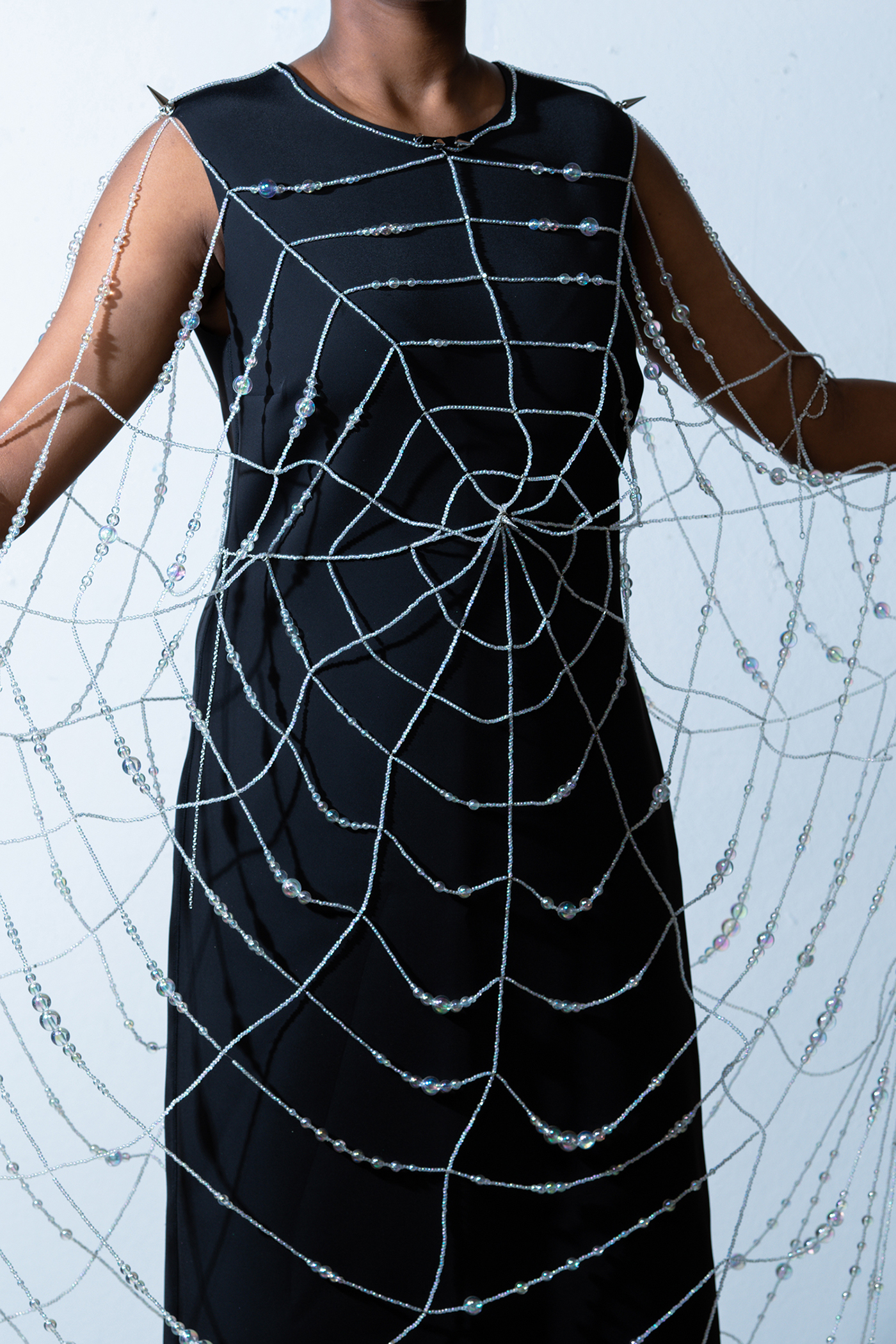Wearable sculpture that mimics a spider web.