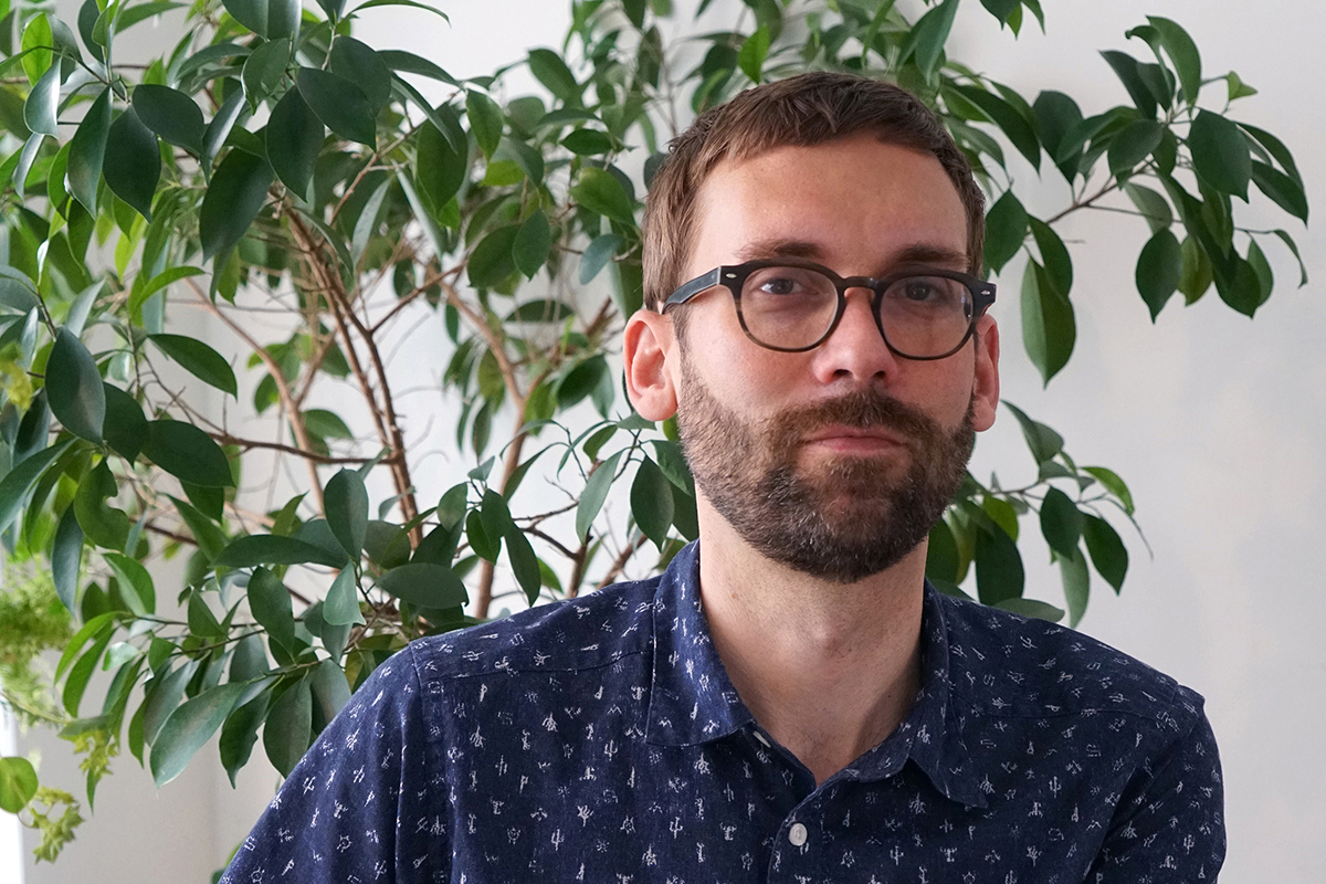 A photo of Josh Thorson, set against the backdrop of a tree.