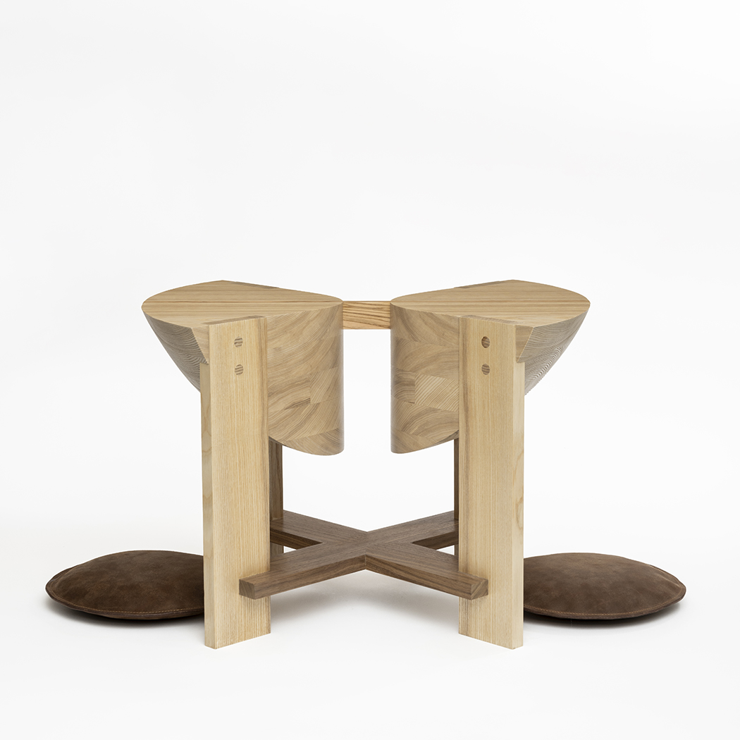 A bench with two places for people to kneel and sit.