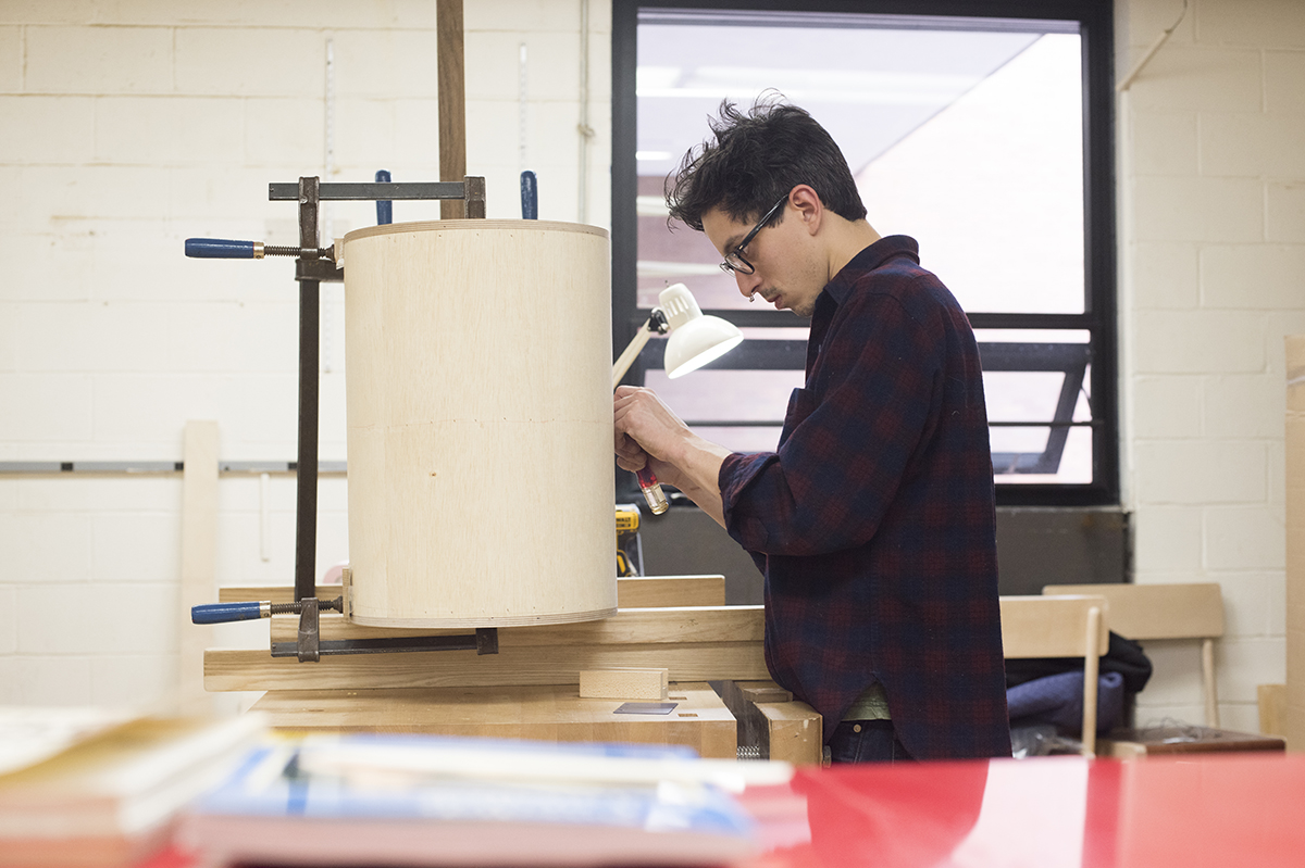 A student works on a large cylinder design in RIT's furniture design studio.