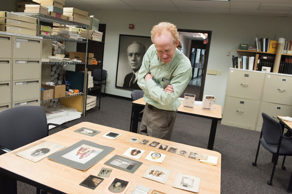 A visitor at the RIT Image Permanence Institute, looking at a collection of photographs.