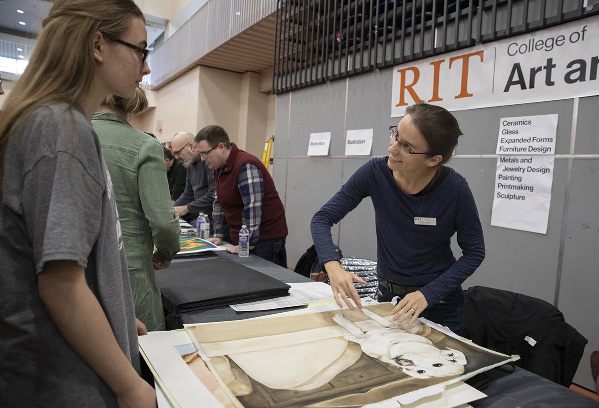 Faculty Emily Glass reviews a student's portfolio during a National Portfolio Day event at RIT.