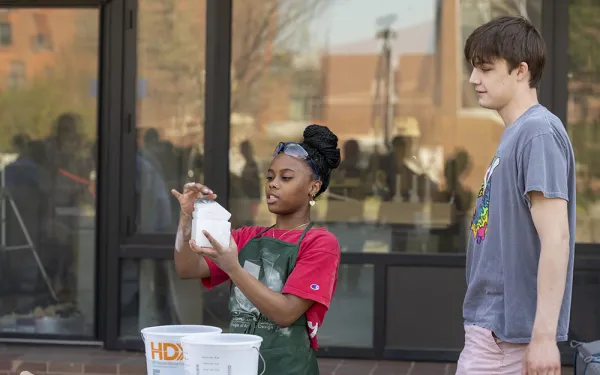 An instructor demonstrates to a student outside.
