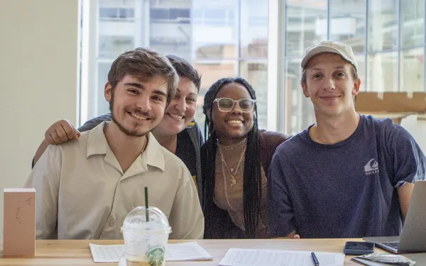 Faculty and students smile together.