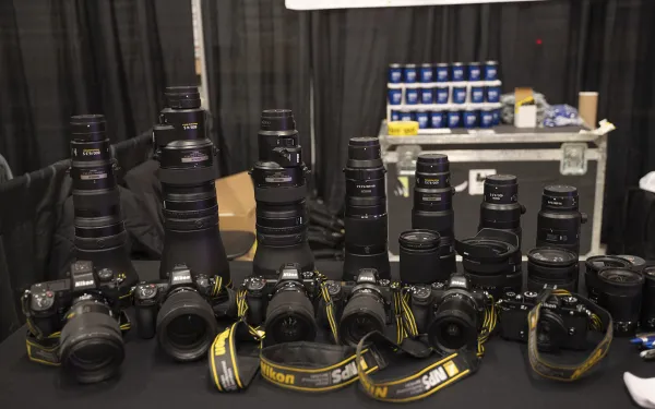 A line of cameras on a table.