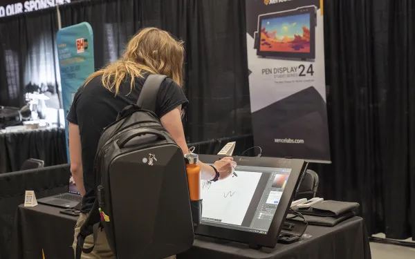 A conference attendee draws on a tablet.