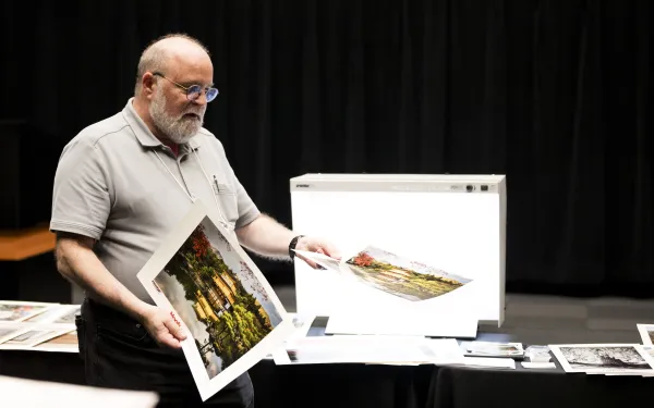 An industry rep shows off color photo prints.