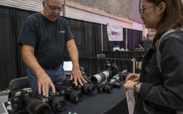 An industry rep shows off camera sitting on a table.