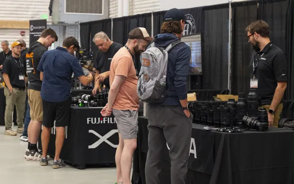 A wide view of a photo trade show, with many booths and attendees.