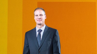A portrait of Todd Jokl in front of RIT's Albers mural.