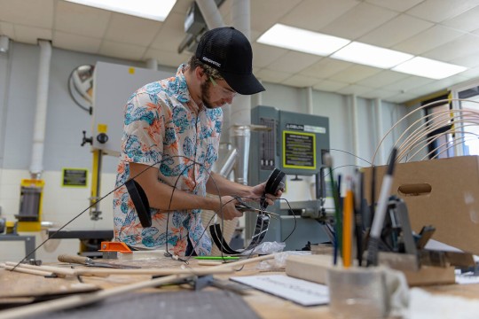 student snips wires in a maker space.