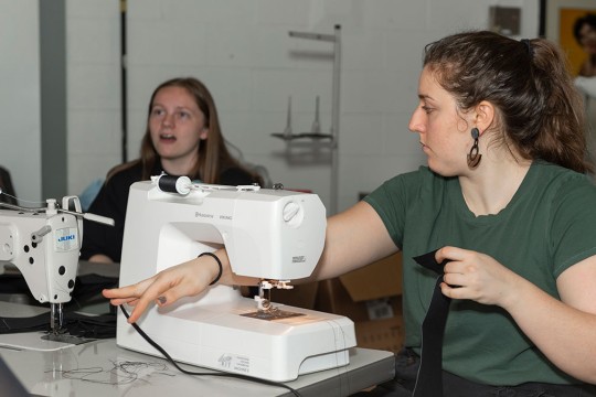 A student works on a sewing machine.