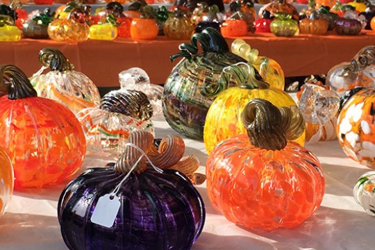 A patch of glass pumpkins on a table.