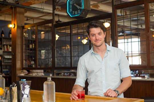Person posing in behind table at bar