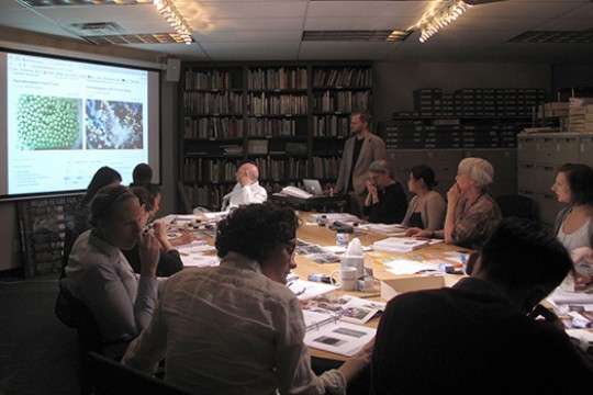 people gathered around table watching presentation