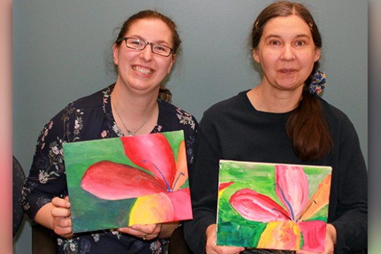 Artists posing for camera with painting