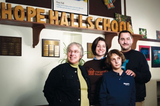 Family Standing in front of "Hope Hall School" sign
