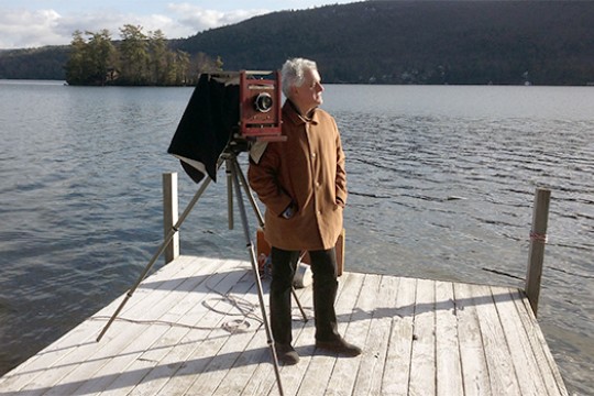 Thomas Shillea standing on a dock with a camera.