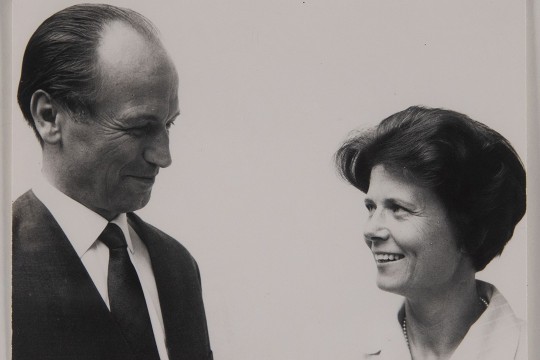 Hermann and Gudrun smile at each other in this black and white photo. They are pictured from the shoulders and chest up.