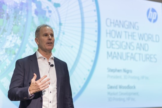 Man talks infront of large screen