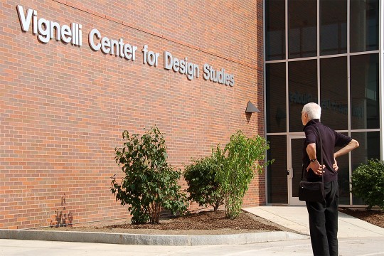 man looking at outside of brick building labeled Vignelli Center for Design Studies.