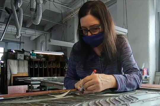 artisan working on stained glass window.