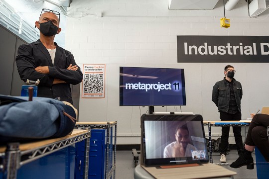 two presenters standing on either side of a TV screen that says: metaproject 11.