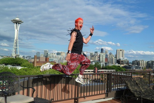 person in mid-air playing air guitar.