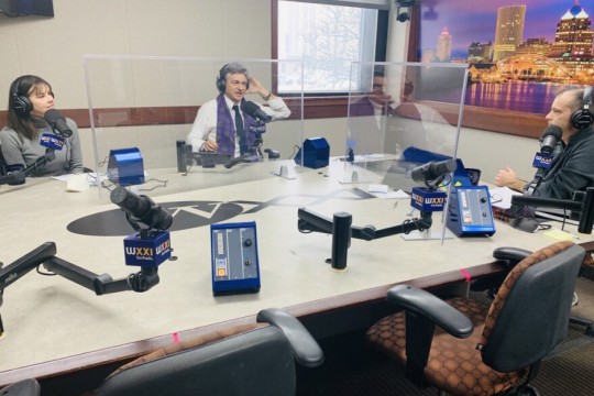 three people talking in a radio station studio.