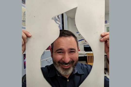 Adam Spector peeks his face through a cutout of a vessel.